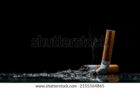Cigarette. tobacco cigarette butt on the floor. World no tobacco day. Sign of stop smoking for no smoking day. Black background.