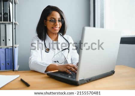 healthcare, medical and technology concept - african female doctor with laptop. Royalty-Free Stock Photo #2155570481