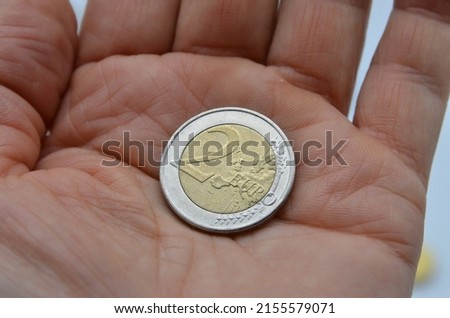 Hand holding  2 euro coin Royalty-Free Stock Photo #2155579071