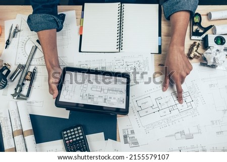 Architect engineer use tablet to read drawing design. House planning design and construction concept. Royalty-Free Stock Photo #2155579107