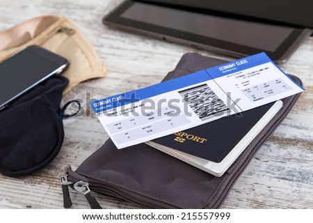 Airline ticket, passport and electronics, preparing to travel  Royalty-Free Stock Photo #215557999