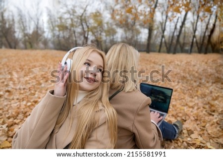 Happy mother and adult daughter on a walk in the autumn park