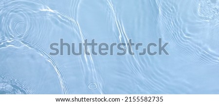Transparent blue clear water surface texture with ripples, splashes. Abstract summer banner background Water waves in sunlight with copy space, top view. Cosmetic moisturizer micellar toner emulsion Royalty-Free Stock Photo #2155582735