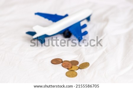 airplane and dollar bills and euro cents coins on white blanket. tourism concept, travel, trips with family friends. book ticket to aircraft. tourism agency, advertising banner. money, saving