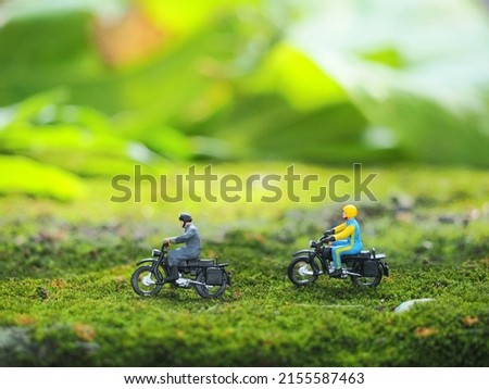 Miniature figure on the green land with blurred green background.