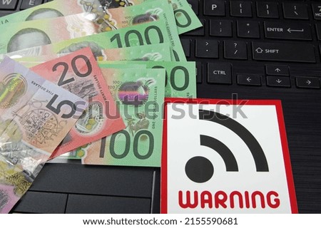 bank notes and wifi warning sign on a black computer keyboard 