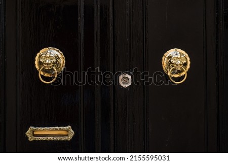 A pair of golden door knockers pictured on a black door in Mdina, Malta in April 2022.