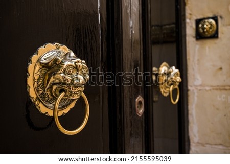 A pair of golden door knockers pictured on a black door in Mdina, Malta in April 2022.