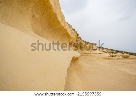 Curved yellow cliffs at Xlendi on the Gozo coastline in Malta pictured in April 2022.