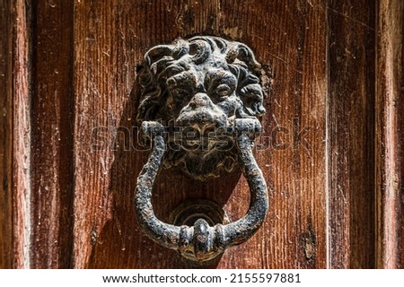 An aging and weathered lion door knocker pictured outside a house in Mdina, Malta during April 2022.