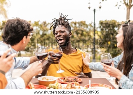 Happy friends having brunch together on the pool patio while drinking red wine - Friendship lifestyle concept with young millenial people enjoying time together 