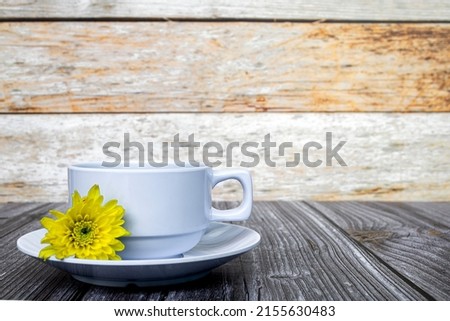 White coffee cup and dahlia flowers on wooden desk. Background. Copy space.