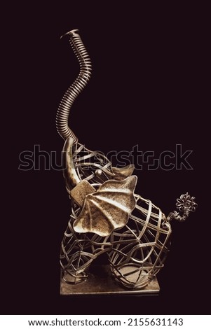 elephant shaped metal mesh netting, trinket on black background