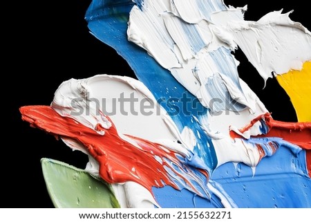 colorful abstract background from smears of oil paint on black palette