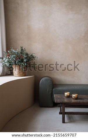Contemporary soft couch, bronze bowls and decorative flowers in room interior design. Home comfort. Apartment details. Fashion flat after renovation. Art deco style