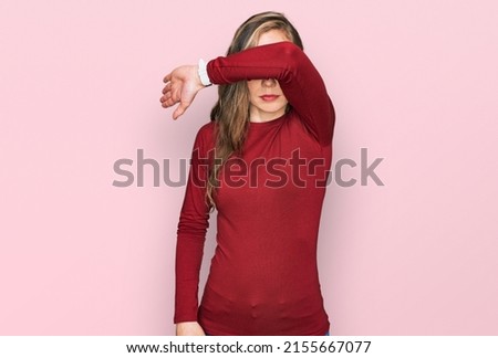 Young blonde woman wearing casual clothes covering eyes with arm, looking serious and sad. sightless, hiding and rejection concept  Royalty-Free Stock Photo #2155667077