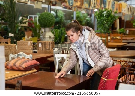 Woman consumer choosing table furniture store. High quality photo