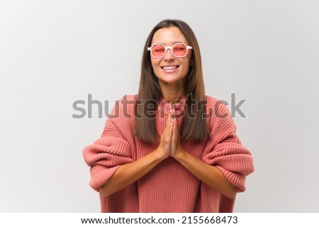 Meditation, religion and spiritual practices. Beautiful woman doing yoga indoors at light white wall, keeping eyes closed, holding hands in mudra gesture. Isolated studio shot