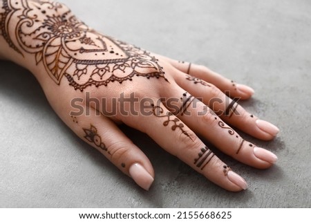 Female hand painted with henna on grunge background, closeup