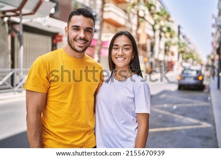 Young latin couple smiling happy and hugging standing at the city. Royalty-Free Stock Photo #2155670939
