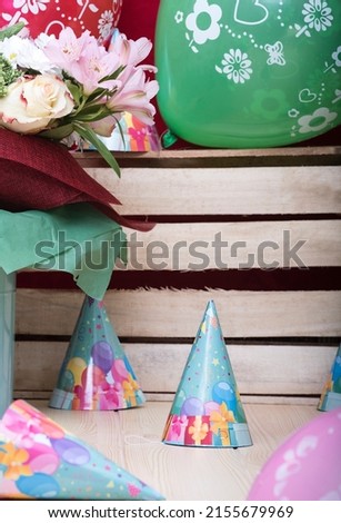 Wooden craft surface as a comfortable background wall and light wooden table with different structures, full of different objects for celebrating happy birthday and other dates, ready for party.