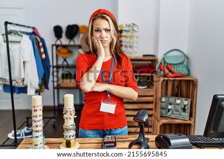 Young caucasian woman working as manager at retail boutique thinking looking tired and bored with depression problems with crossed arms. 
