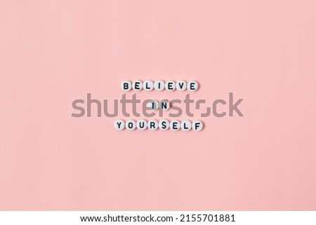 Top view of "believe in yourself" quotes made out of beads on pink background. motivation and success concept Royalty-Free Stock Photo #2155701881