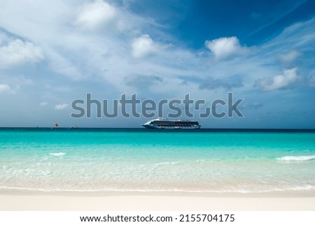 The turquoise color waters on Half Moon Cay island and a drifting cruise ship in a background (Bahamas).