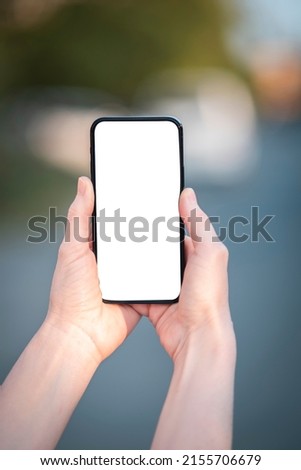 Hands holding amsrtphone with blank screen without notch
