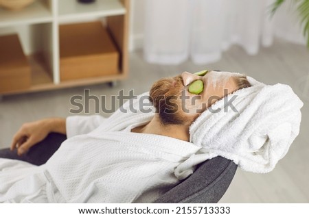 Metrosexual man in bathrobe make beauty face skin procedures for glowing healthy look. Calm guy relax on spay day at home, do cosmetic facial treatment or mask. Male skincare and cosmetology. Royalty-Free Stock Photo #2155713333