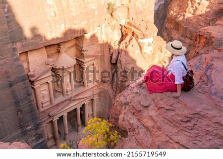 young tourist with hat and fashion dress  at Al-Khazneh (The Treasury) one of the most elaborate temples in the ancient city of Petra, Jordan. View from above. Royalty-Free Stock Photo #2155719549