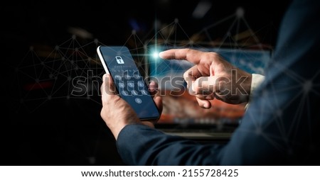 Hacking a Phishing mobile phone with a password to access a smartphone, internet security issues, and fraud are all concepts.A businessman with a mobile phone and a laptop computer has a safe account. Royalty-Free Stock Photo #2155728425