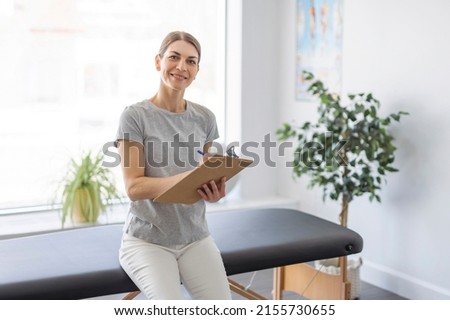 Modern rehabilitation physiotherapy woman worker at job with note pad