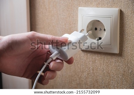 Turning off appliances that are not working saves energy. Unused phone chargers or power adapters. Plug the charging adapter into a European socket. Charging block yusb with interface type c Royalty-Free Stock Photo #2155732099