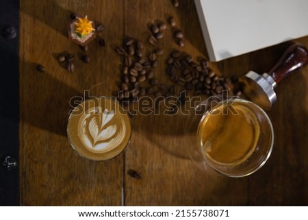 cup of coffee latte art put on  barista wooden table. 