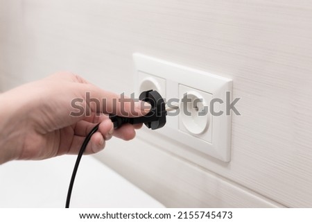 cord with plug from the electrical device to the socket. close-up Royalty-Free Stock Photo #2155745473