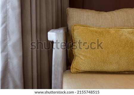 
Yellow ultimate colored pillows on sofa with gray curtain.  Modern interior design, cozy textile sweet home. 