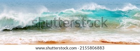 Blue and aquamarine color sea waves and yellow sand  with white foam. Marine beach background. Banner format.