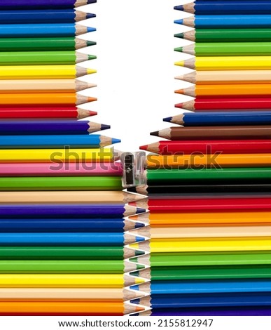 Background of color pencils in a variety of colors and a sharpener.