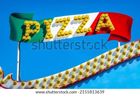 typical pizzeria sign in front of blue sky - photo