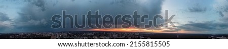 Dramatic ultra wide sunset cloudscape panorama view in city residential district. Aerial Pavlovo Pole, Kharkiv Ukraine. Evening skyscape, cloudscape with heavy dark clouds and orange sun Royalty-Free Stock Photo #2155815505