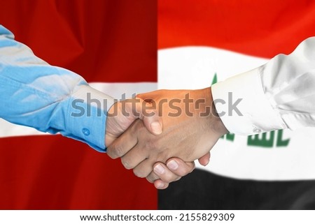 Business handshake on background of two flags. Men handshake on background of Iraq and Latvia flag. Support concept