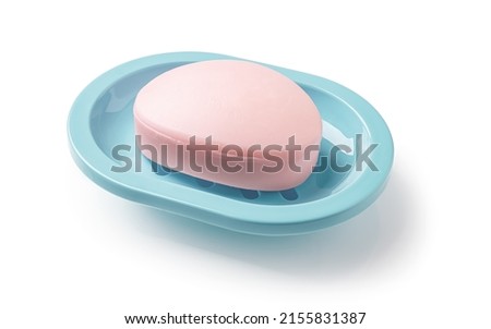 Pink soap bar in a teal blue dish isolated on a white background. Oval shaped bar of soap on a plastic holder for bathroom and shower. Purity, toiletries and washing hands concepts. Top view. Royalty-Free Stock Photo #2155831387