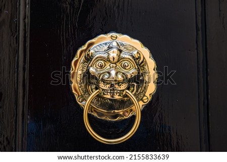Close up of a golden door knocker pictured on a black door in Mdina, Malta in April 2022.