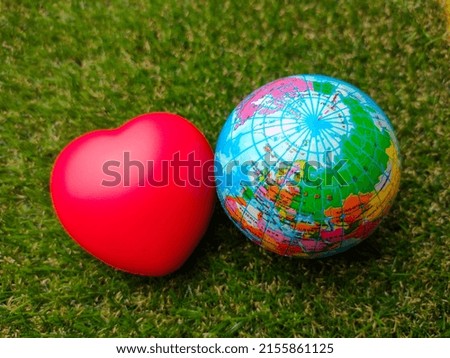 Earth globe with red heart on a green grass background. Royalty-Free Stock Photo #2155861125