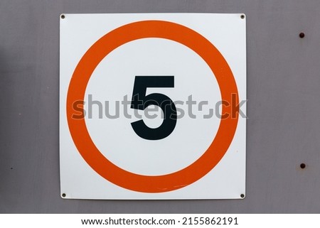 5 miles per hour speed limit sign black text in a red circle on a white background