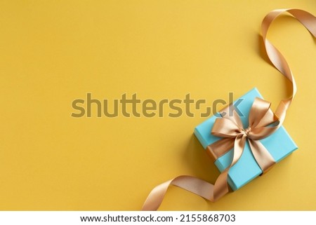 Image of a refreshing gift with a plain yellow background and a blue gift Father's Day