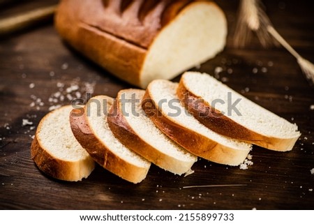 Sliced wheat bread. On a wooden background. High quality photo