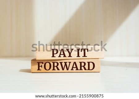Wooden blocks with words 'Pay it forward'. Business concept