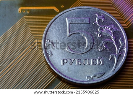 A coin with a face value of 5 rubles lies on a microcircuit. close-up. Translation of the inscription on the coin: "5 rubles" The concept of the digital economy in the Russian Federation